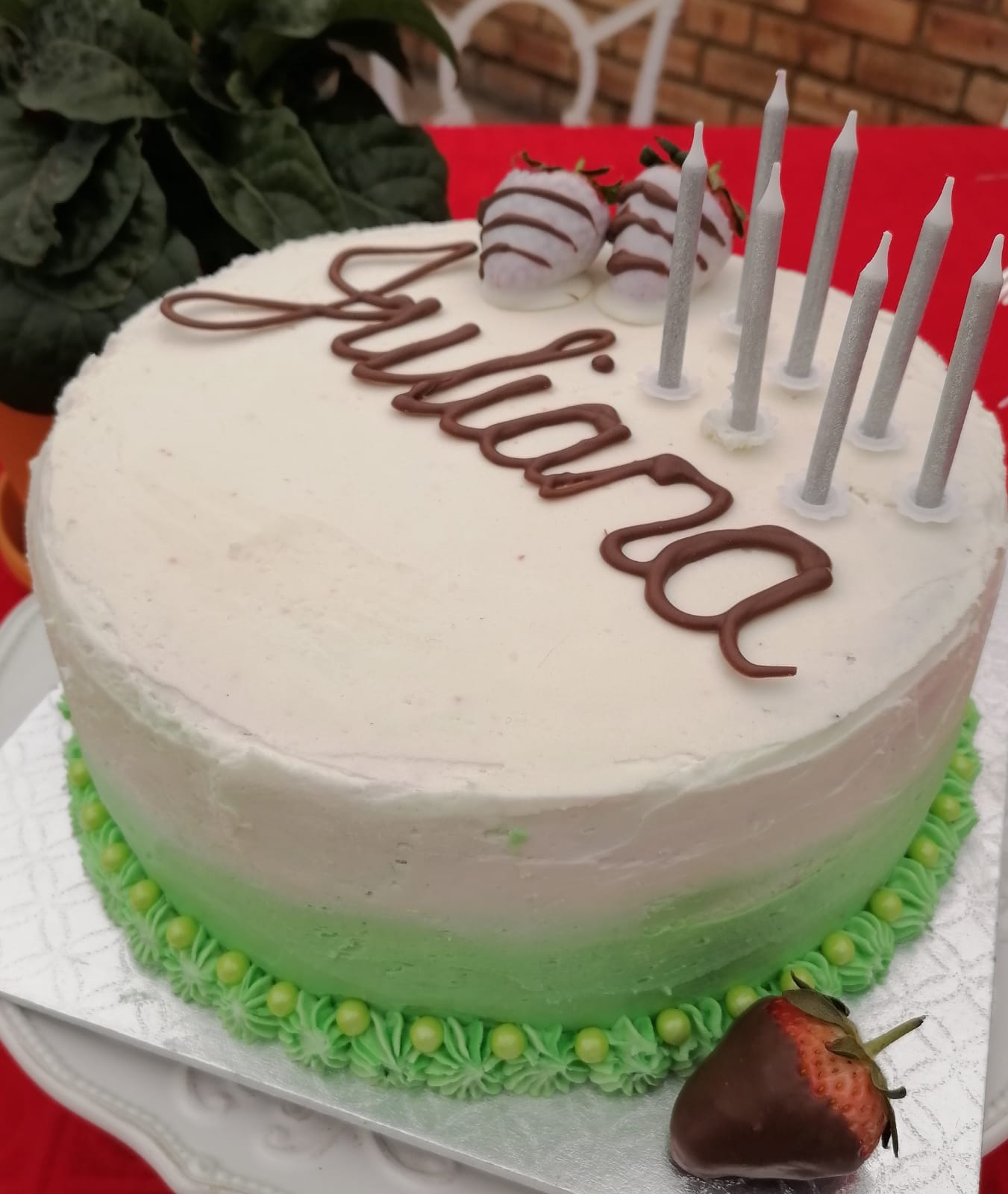White cake with chocolate lettering and candles