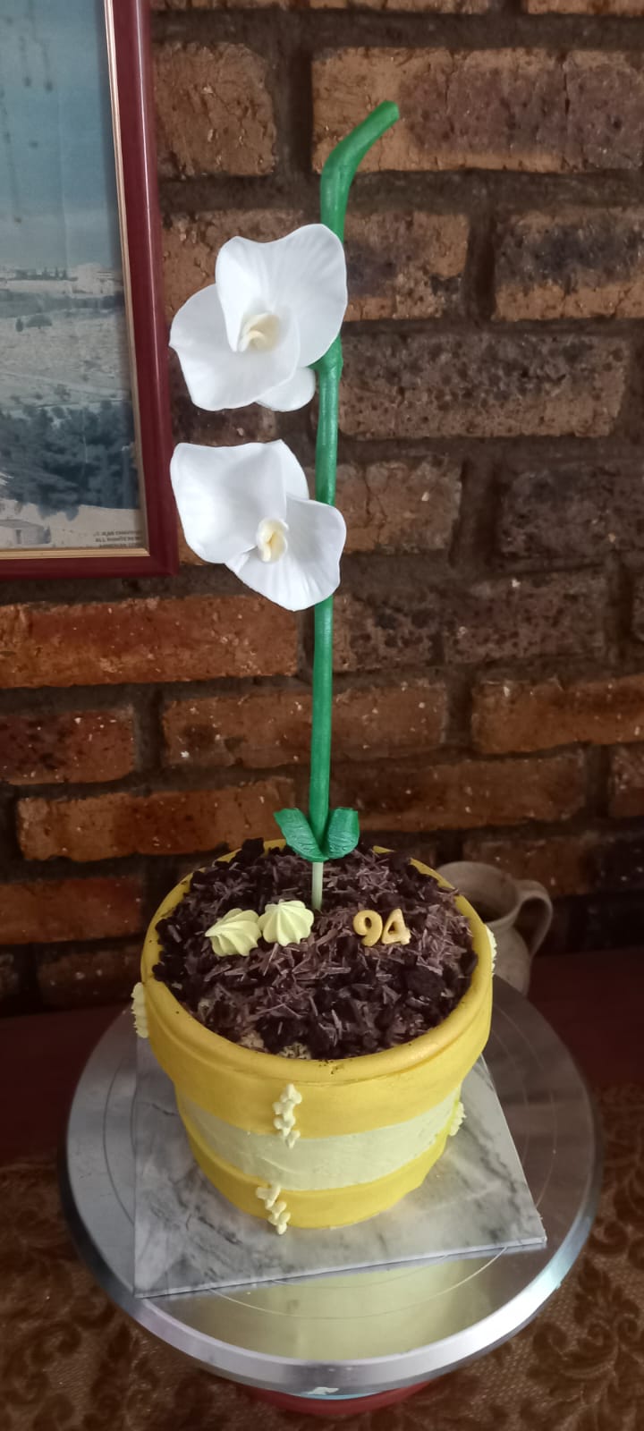 Yellow flower pot cake with chocolate soil and white orchid flowers