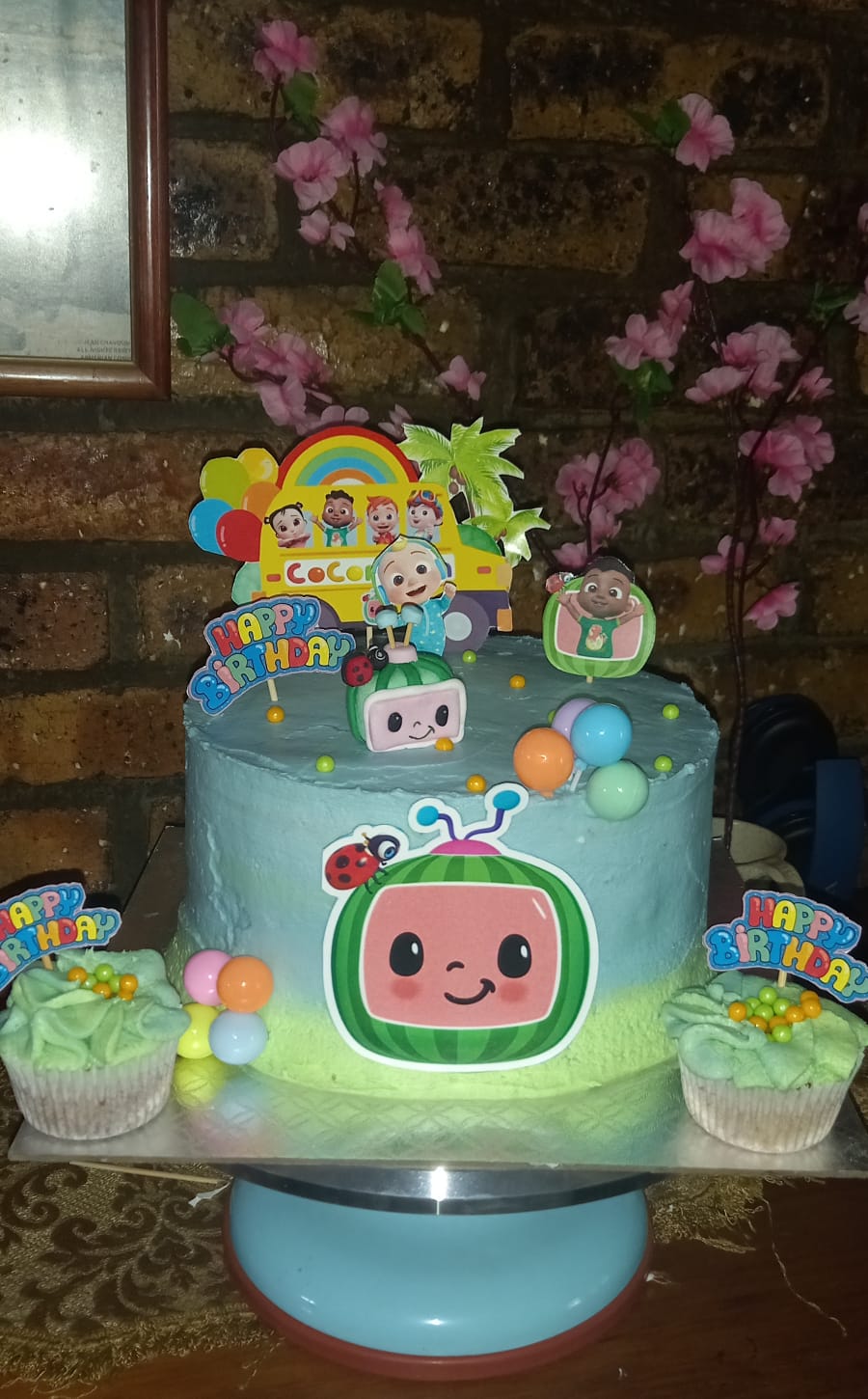 CoComelon themed birthday cake with blue frosting and character decorations