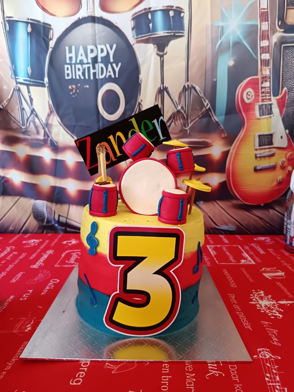 Music-themed birthday cake with drum set topper