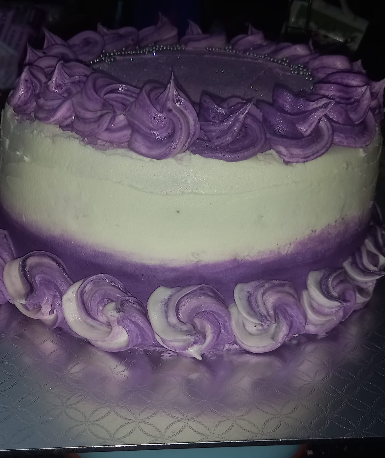 Purple and white ombre cake with decorative frosting rosettes